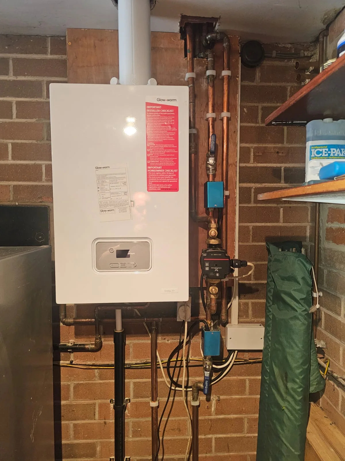 Glow-worm boiler installation with surrounding copper pipework and pump