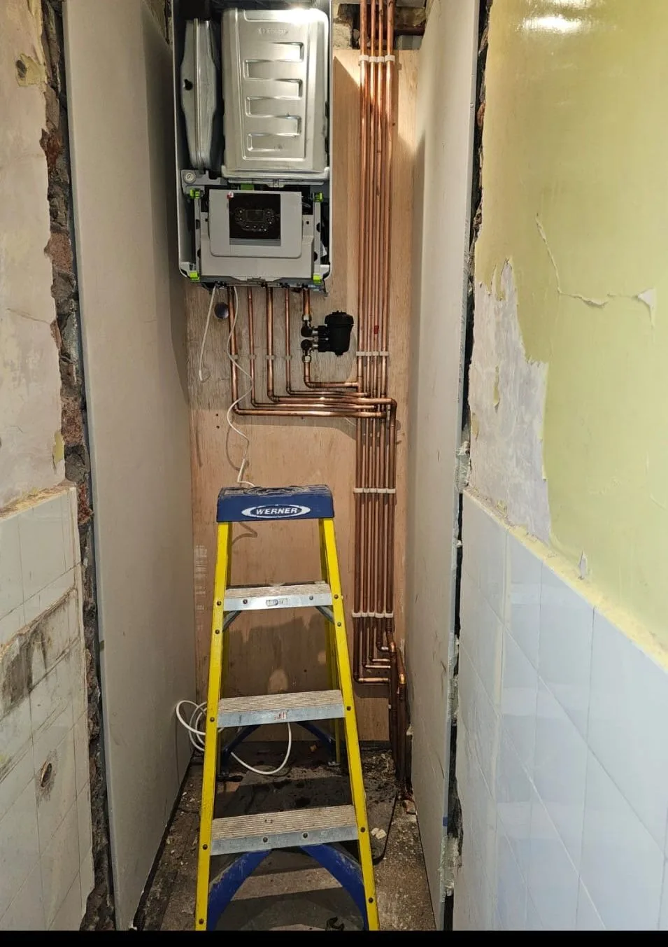 Boiler installation with extensive copper pipework running to a filter and controls